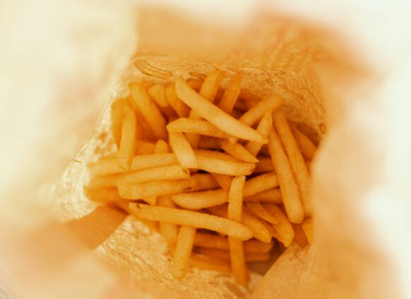 French fries in a paper bag viewed from above, associated with high cholesterol risk