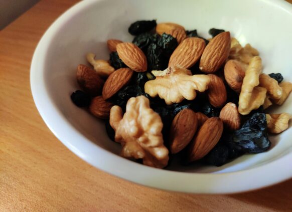 Bowl of mixed nuts and dried fruits including almonds, walnuts, and raisins