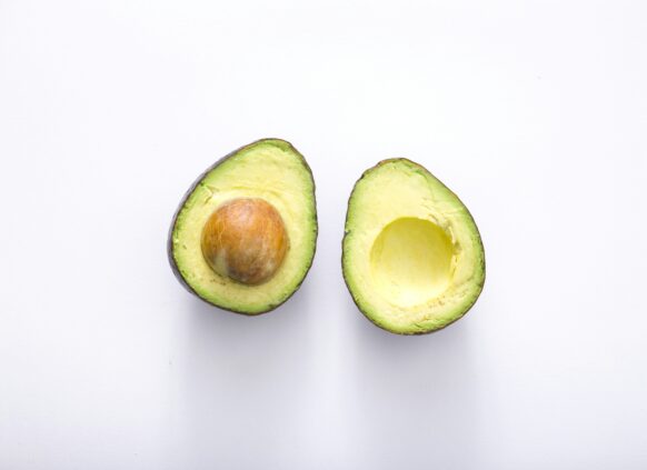 Fresh halved avocado on white background, a heart-healthy food to lower cholesterol