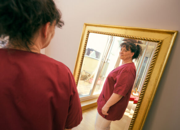 Oviva user looking at herself happily in the mirror