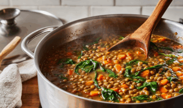 Large saucepan filled with lentil and spinach soup