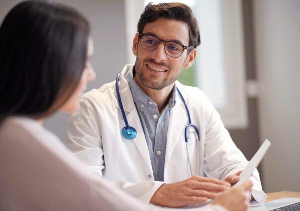 GP smiling at a patient in a doctor's office