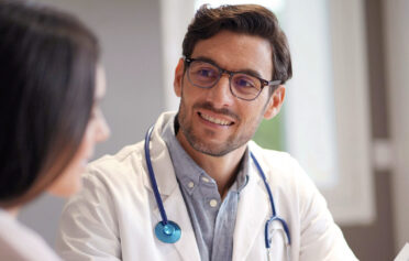 GP smiling at a patient in a doctor's office