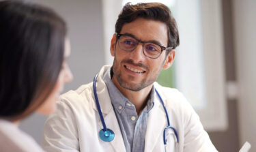 GP smiling at a patient in a doctor's office