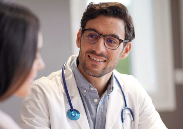 GP smiling at a patient in a doctor's office