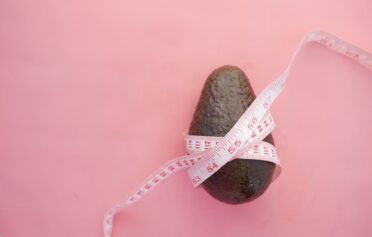 An avocado wrapped in a tape measure