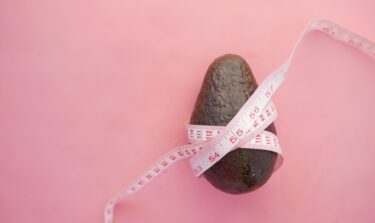 An avocado wrapped in a tape measure