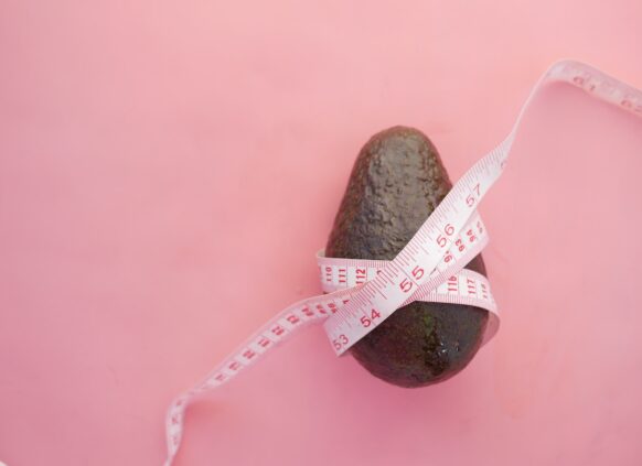 An avocado wrapped in a tape measure
