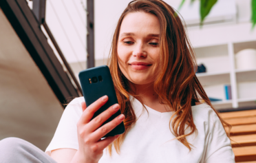 Young woman smiling and looking at her phone