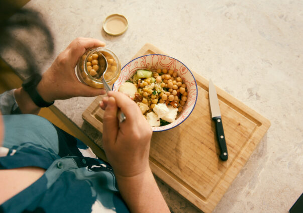 Woman making healthy chickpea bowl for lunch