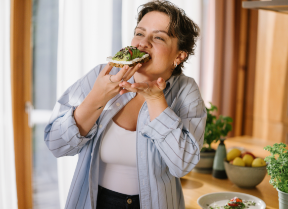 Woman eating toast in the kitchen