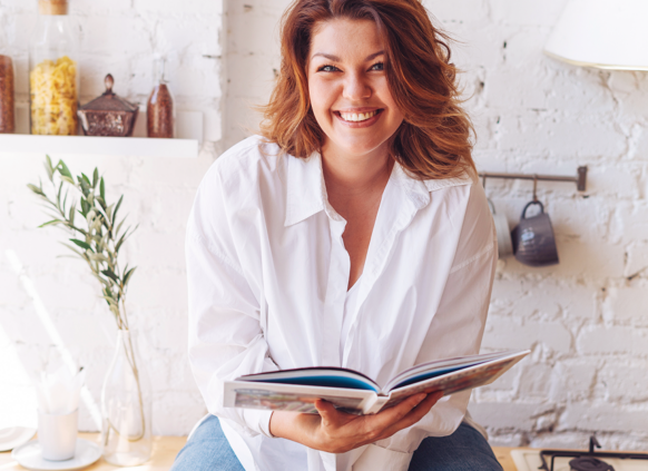 Happy woman sitting and reading a book