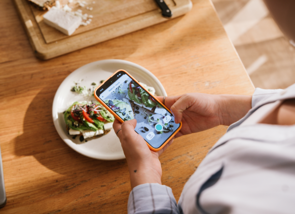 Woman taking a photo of her meal to add to the Oviva food diary app