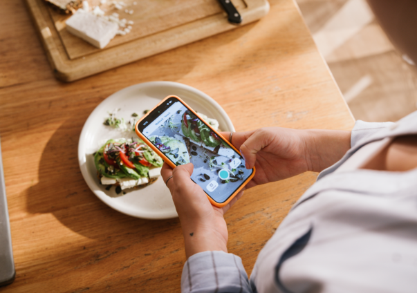 Woman taking a photo of her meal to add to the Oviva food diary app