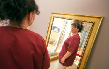 Woman looking at herself happily in the mirror