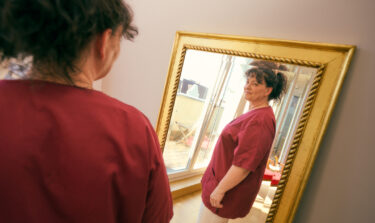 Woman looking at herself happily in the mirror