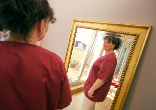 Woman looking at herself happily in the mirror