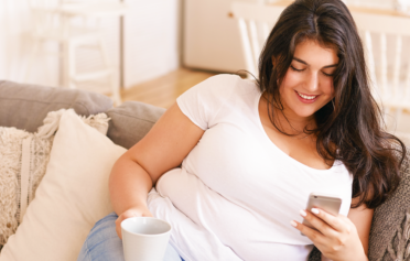 overweight woman smiling and looking at her phone
