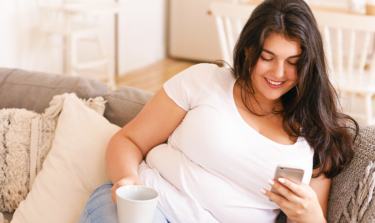 overweight woman smiling and looking at her phone