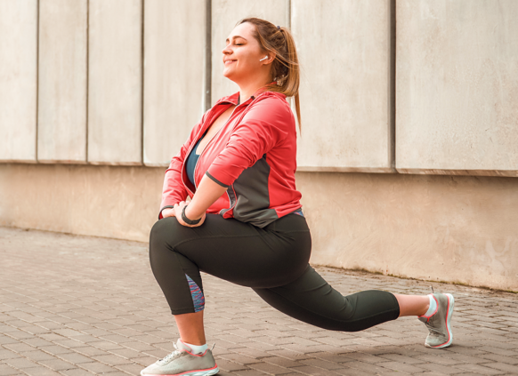 Woman smiling while doing a runner's lunge