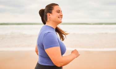 Overweight woman running on the beach