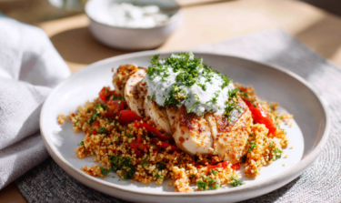 Healthy recipe of turkey with bulgur wheat, peppers & herb yoghurt on a white plate