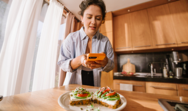A woman taking a picture of her healthy meal